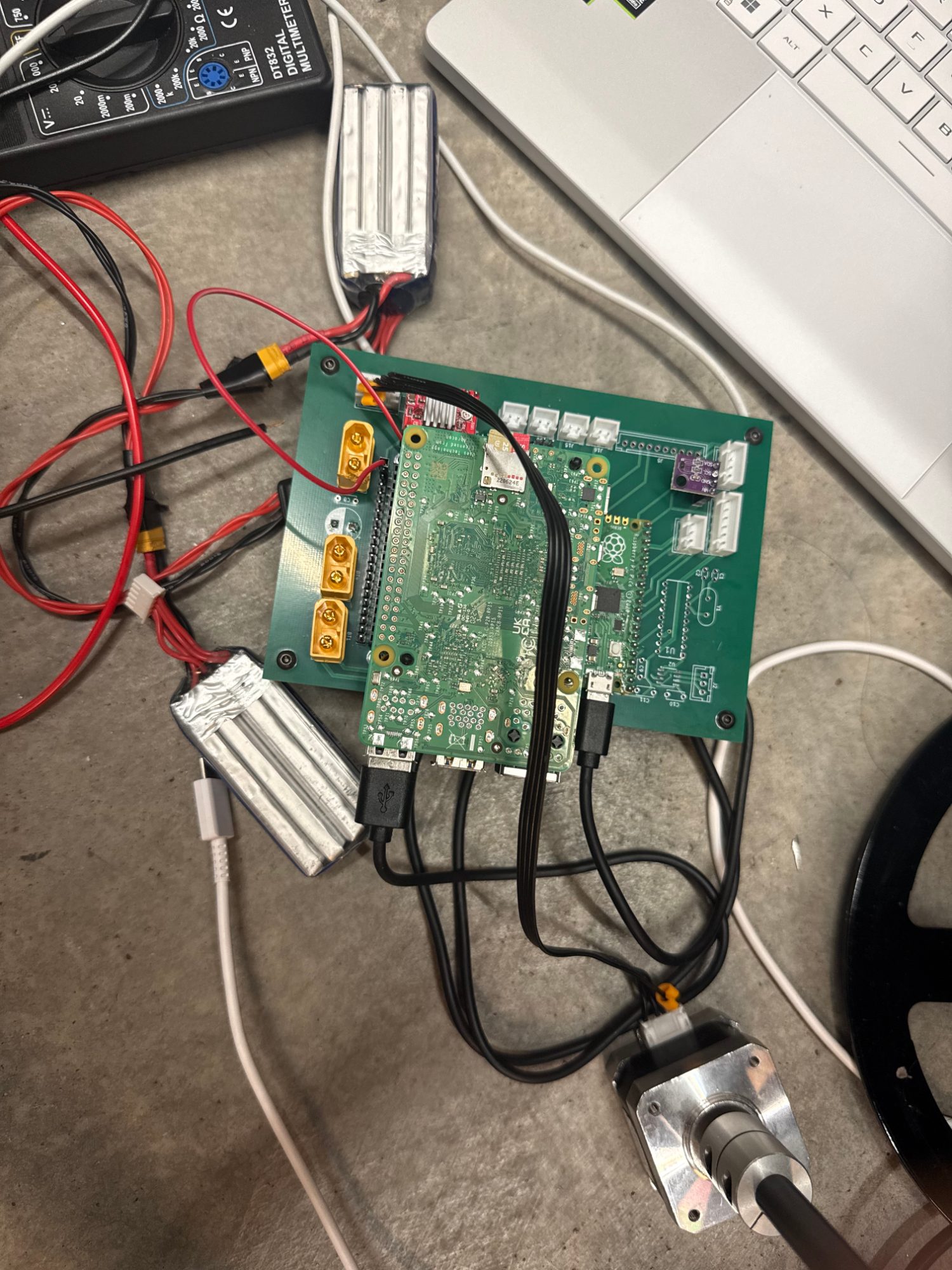 REV 02 board on the bench with a Raspberry Pi and Pico seated, batteries and a motor wired in