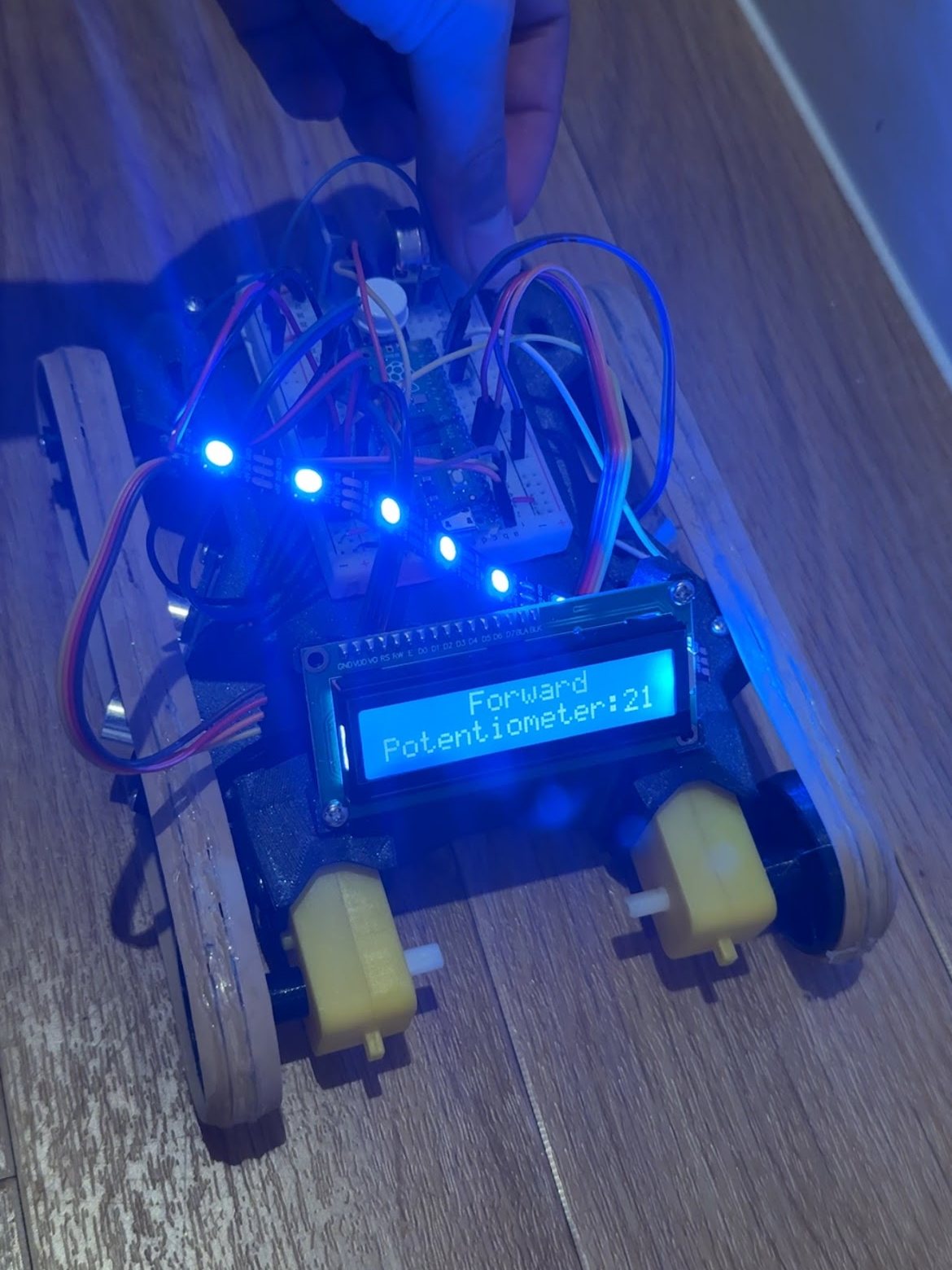 The robot's LCD reading Forward, with the potentiometer value on the line below, lit by its blue LED strip