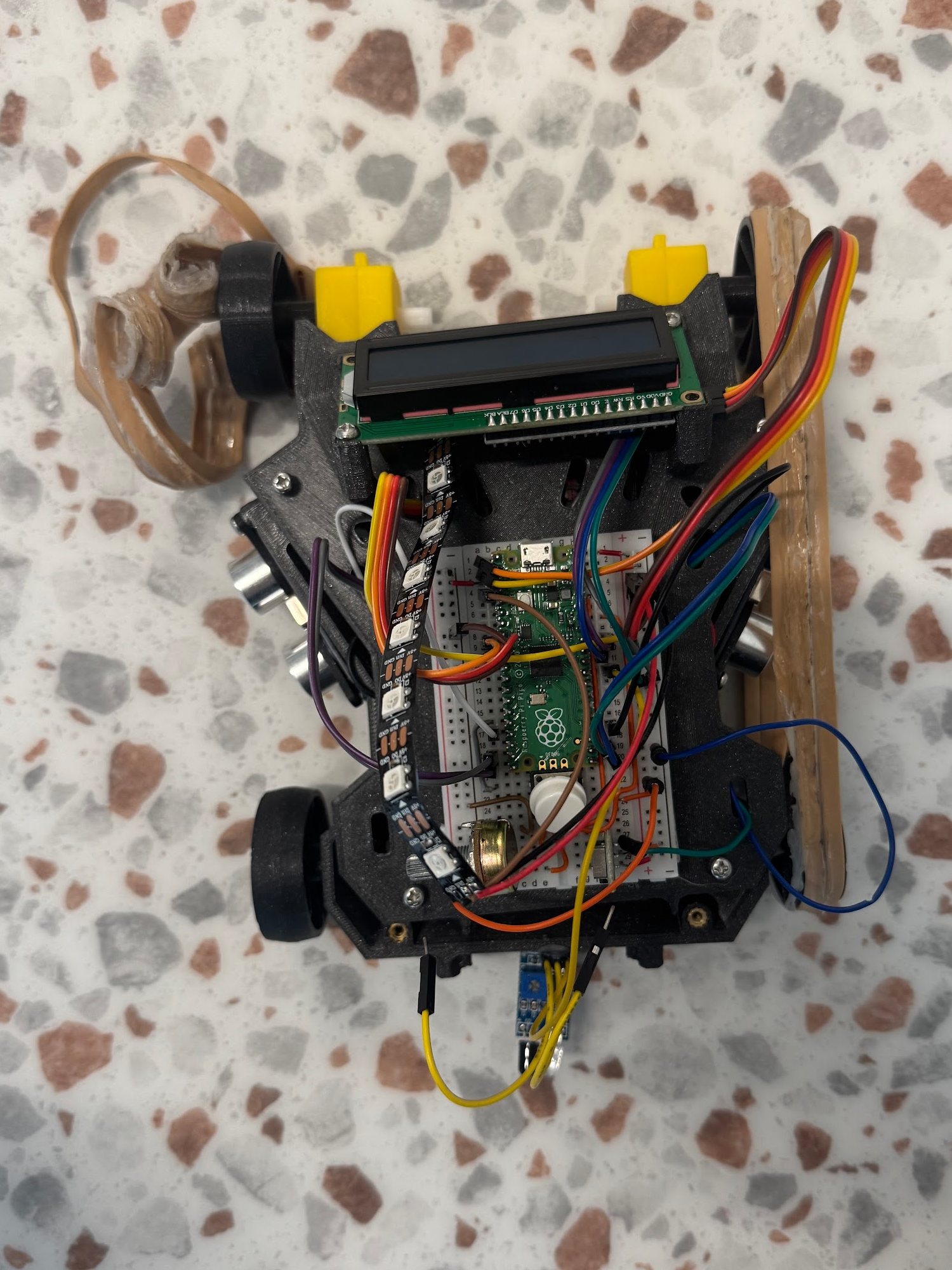 The robot from above with one rubber-band tread slipped off its wheels