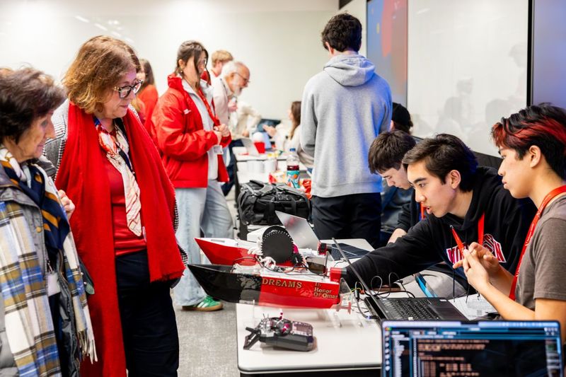 Visitors gathered around D.R.E.A.M.S V1 at the Creators' Showcase